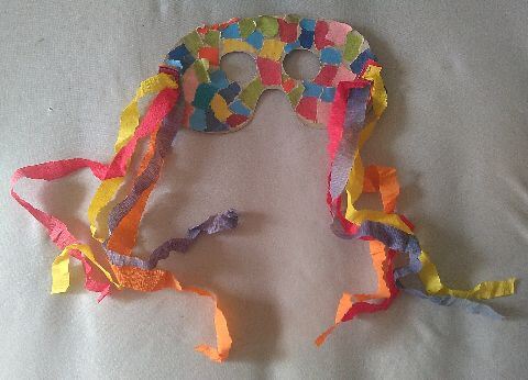 Gebastelte Maske aus gerissenem Papier und Krepppapierbändeln