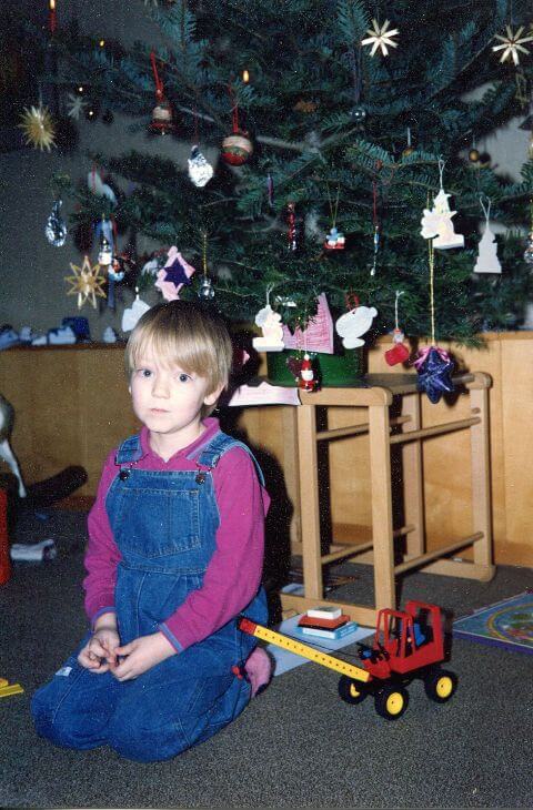 Ich sitze vor dem Weihnachtsbaum, neben mir ein Fischertechnik-Kranwagen