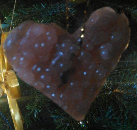 rotes Wachsherz an einem Weihnachtsbaum