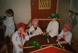 Ich sitze im Nachthemd mit anderen Kindern an einem Tisch